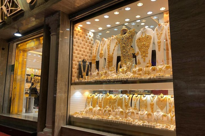 Shimmering gold jewelry illuminates the windows of the Gold Souk inviting travelers to explore a dazzling array of exquisite pieces that reflect Dubai's rich heritage and craftsmanship.